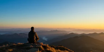 Person meditating on a mountain, embodying mental fortitude and resilience for 2025 challenges.